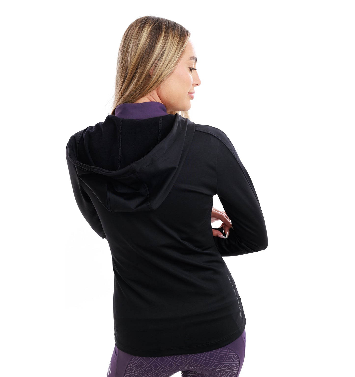 
                  
                    Woman wearing a black hoodie with purple patterned leggings on a white background
                  
                