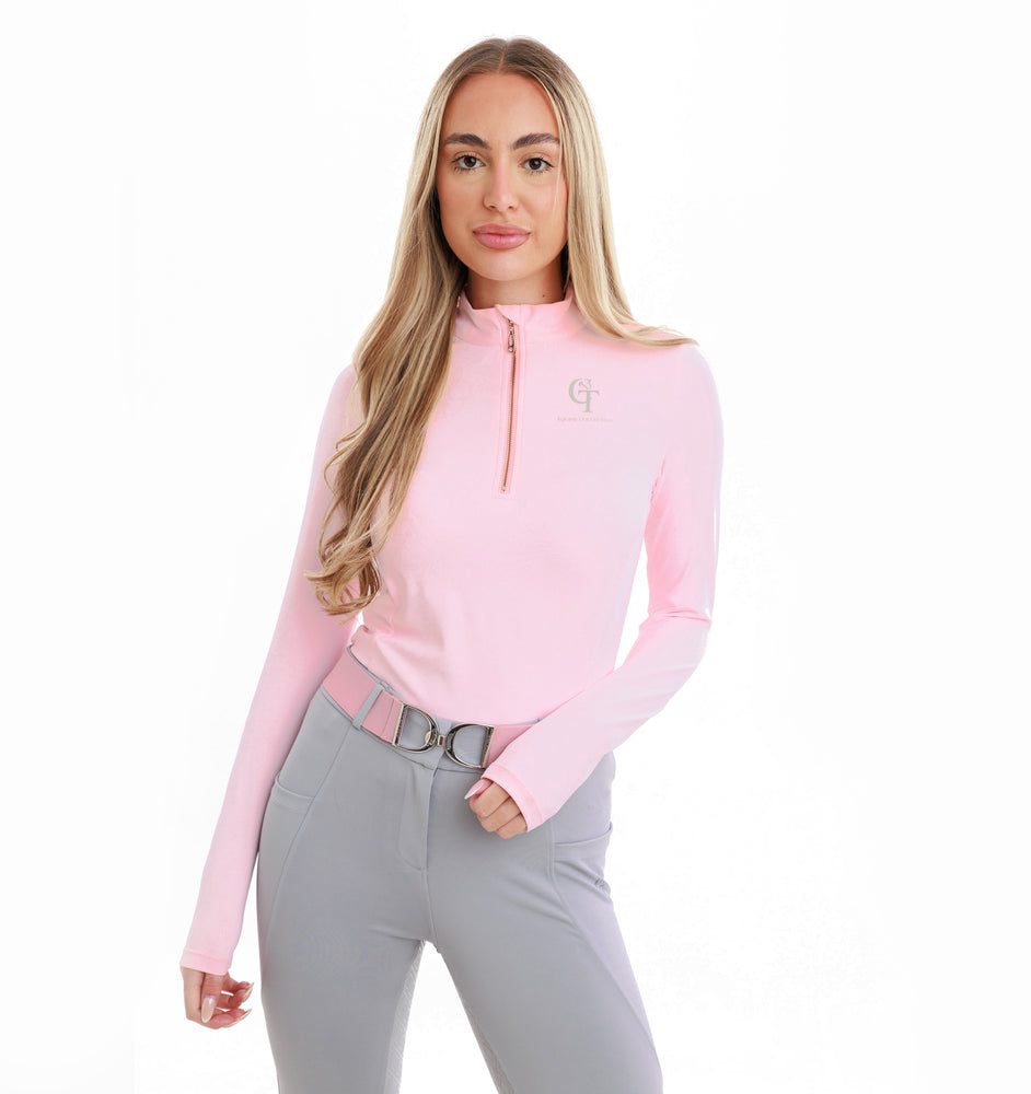 
                  
                    Woman wearing a pink long-sleeve top and grey trousers on a white background
                  
                