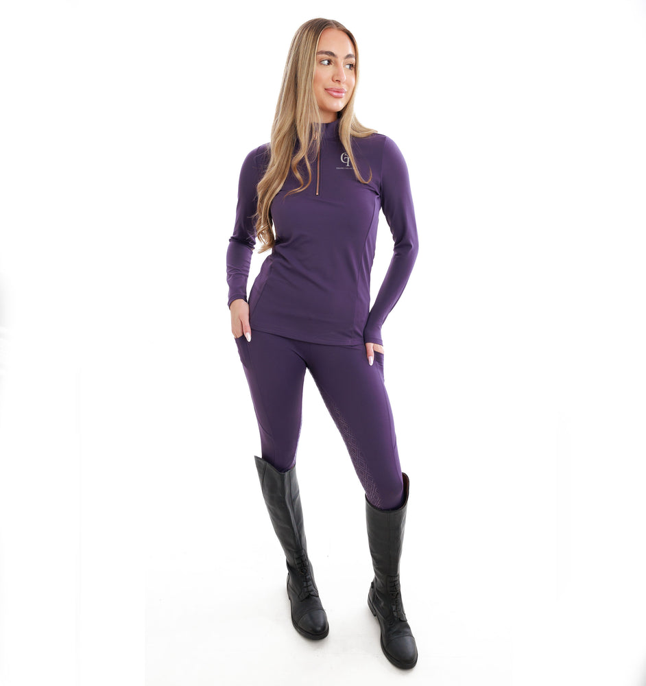 
                  
                    Woman wearing a purple outfit with black boots on a white background
                  
                
