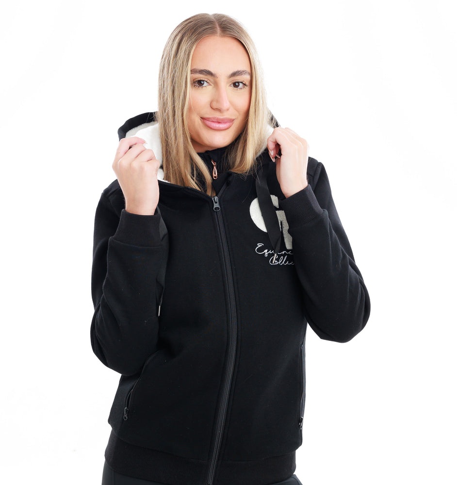 
                  
                    Woman wearing a black hoodie with text, holding onto the jacket hood on a white background
                  
                