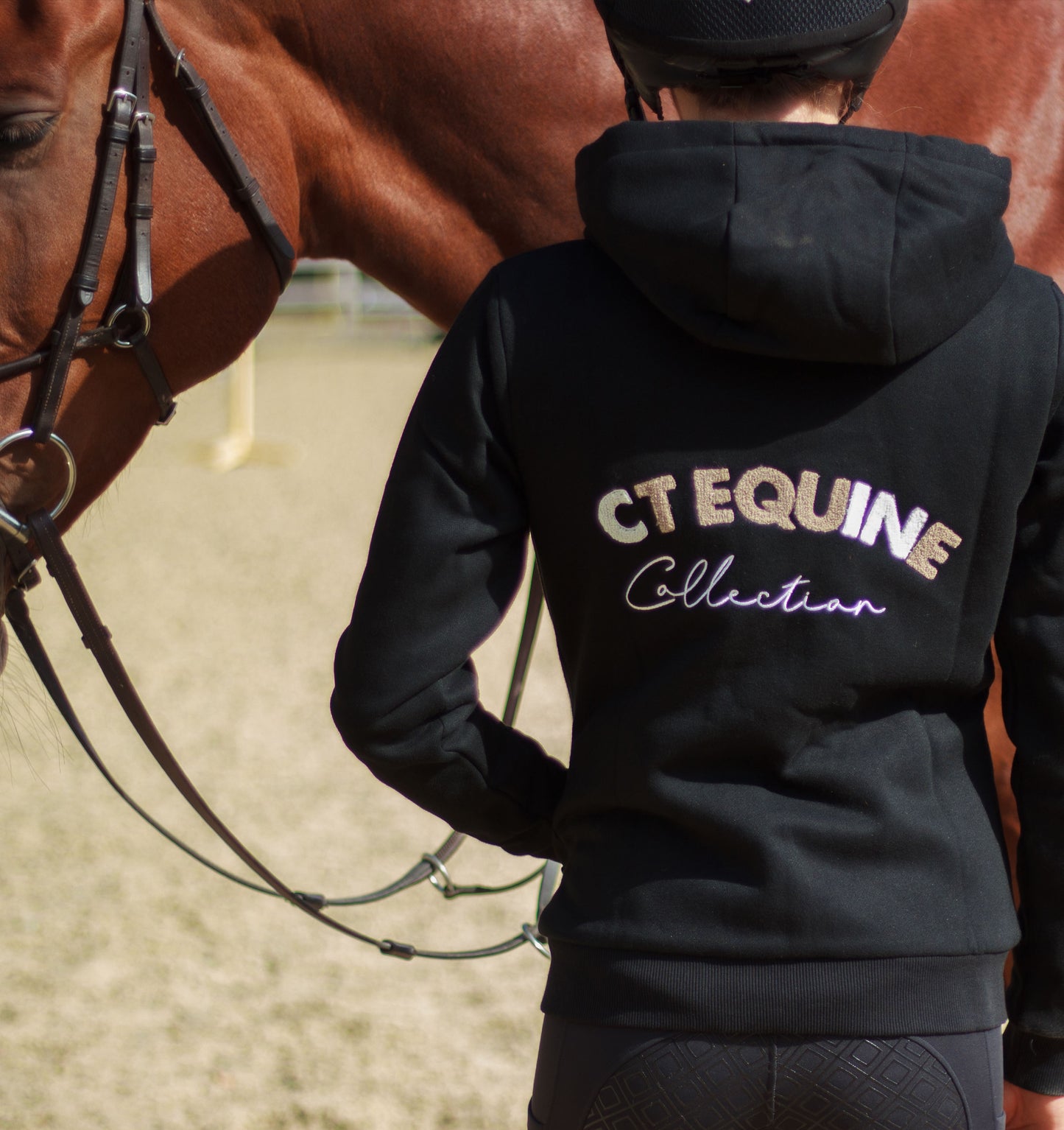 
                  
                    Person wearing a black hoodie with 'CT Equine Collection' text, standing next to a horse.
                  
                