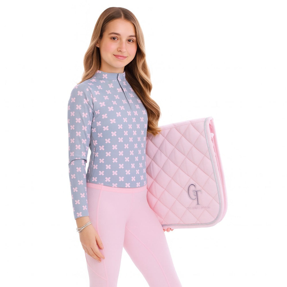 
                  
                    Girl holding a pink quilted saddle pad with a blue and pink butterfly-patterned top on a white background
                  
                