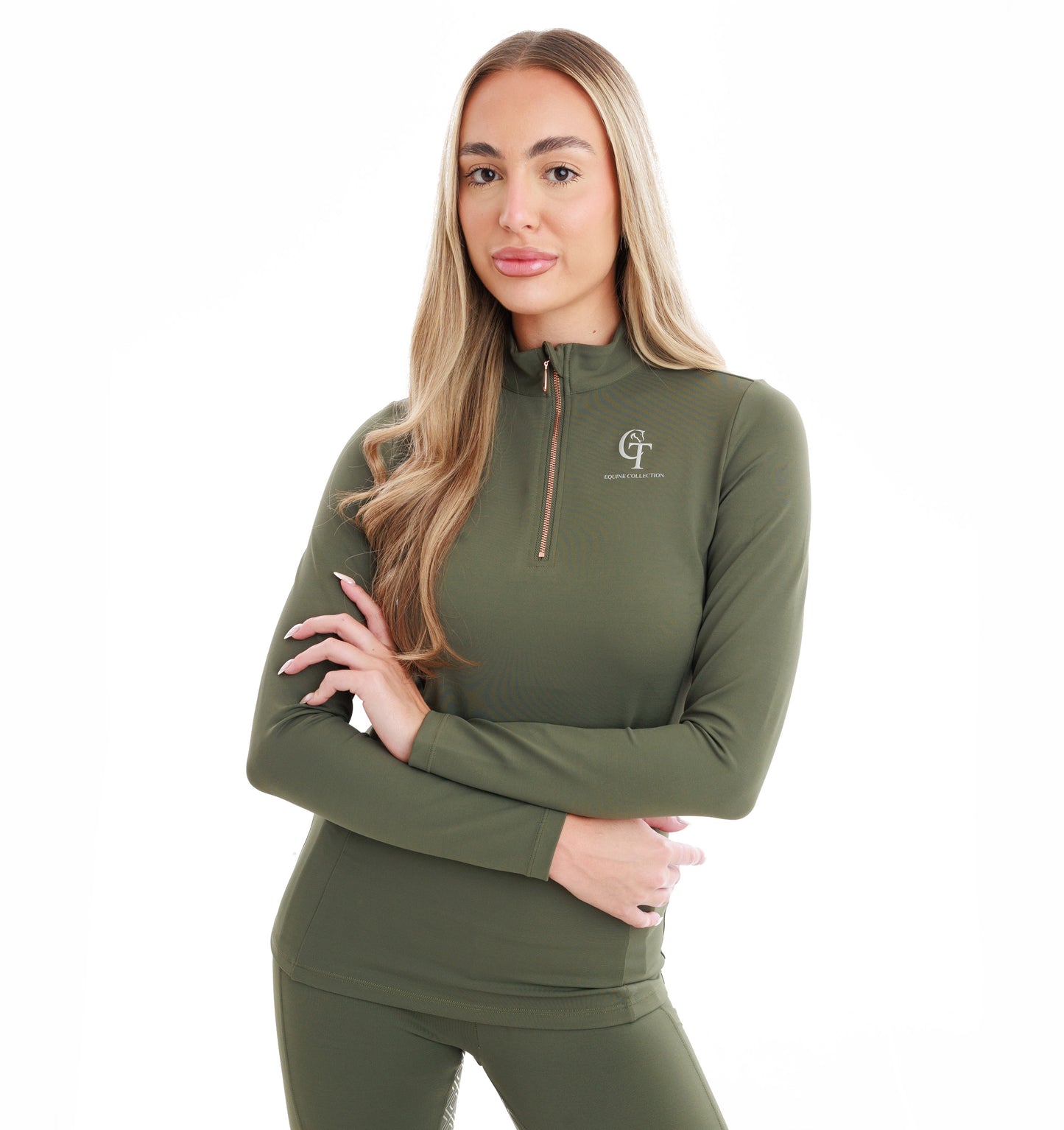 Woman with arms folded wearing an olive green athletic outfit with a logo on a white background